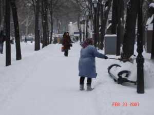 a babushka sweeps the snow